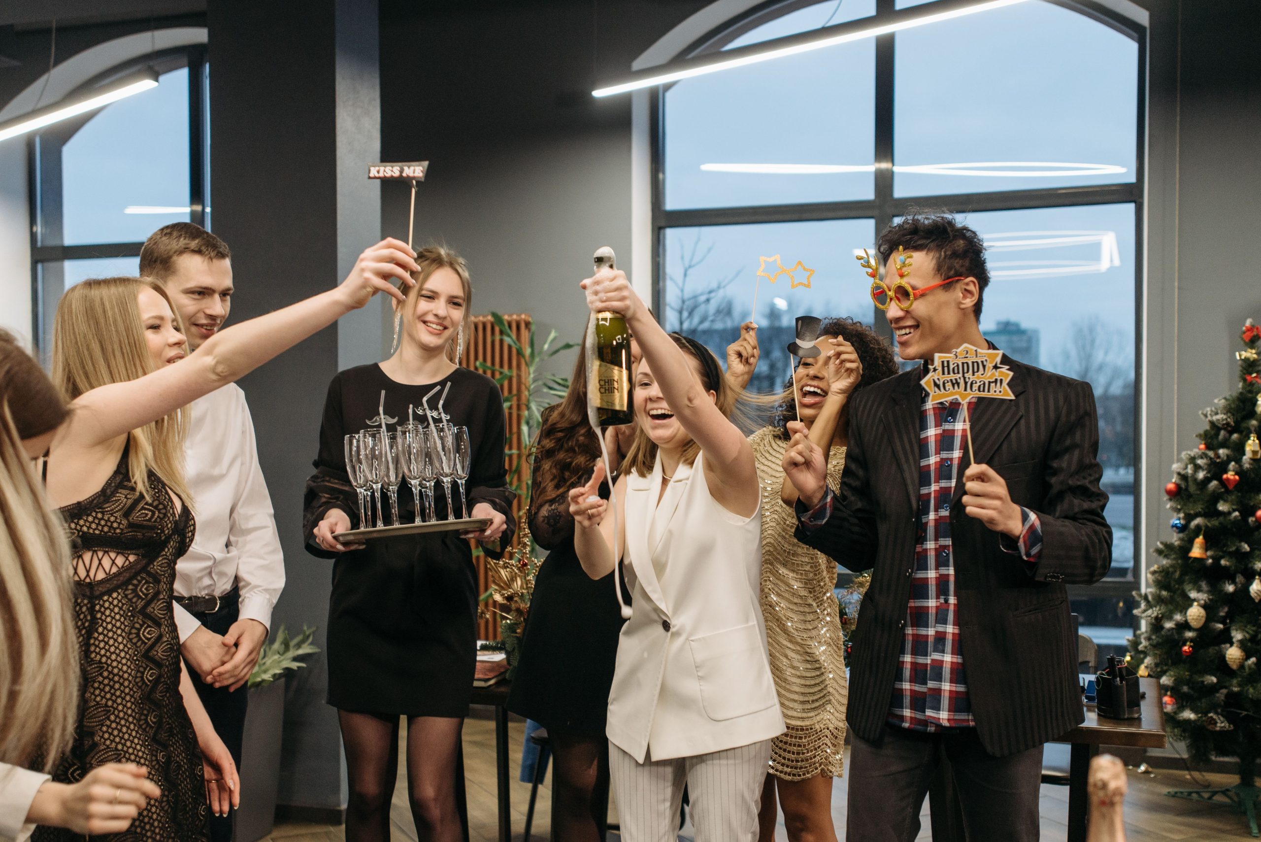 Joyful group celebrating New Year with champagne and festive decorations.